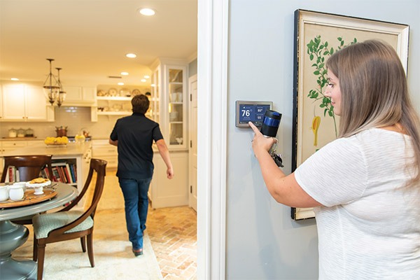 Woman adjusting thermostat